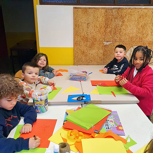 Groupe d'enfants qui jouent à des jeux autour d'une table.